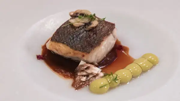 Delicioso filete de lubina a baja temperatura, con champiñones y una guarnición de puré verde.